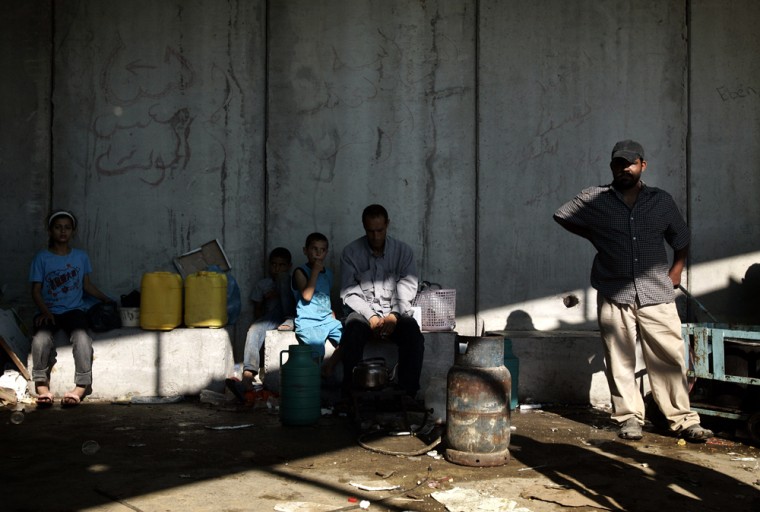 Palestinians wait to cross as they try to flee to the Israeli side of the Erez Crossing, in the northern Gaza Strip,Tuesday, June 19, 2007. Hundreds of terrified Gazans fleeing Hamas rule were trapped at a main crossing with Israel on Tuesday, hoping to gain permission to pass through Israeli territory to sanctuary in the West Bank. Fearing death or persecution, Gazans began flocking to the Erez passage after Hamas militants wrested control of the coastal strip from Fatah security forces late last week. Israel, which has no interest in letting masses of Gazans pass through its territory and possibly destabilize the quieter West Bank, has refused to let most of them in, saying their lives were not in danger.