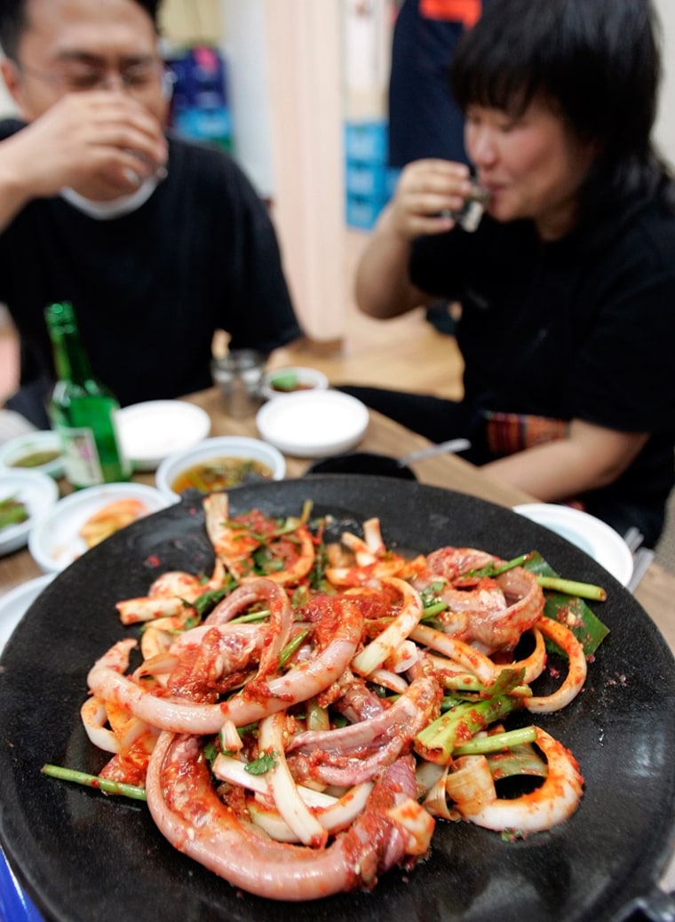 South Koreans drink in front of hagfish before it is broiled at a seafood restaurant in Seoul, South Korea, Sunday, June 10, 2007. The overseas appetite for the hagfish _ also known as the slime eel _ is creating a business opportunity for struggling American fishermen on the West Coast confronted with tough restrictions on the catching of salmon and other fish. (AP Photo/ Lee Jin-man)