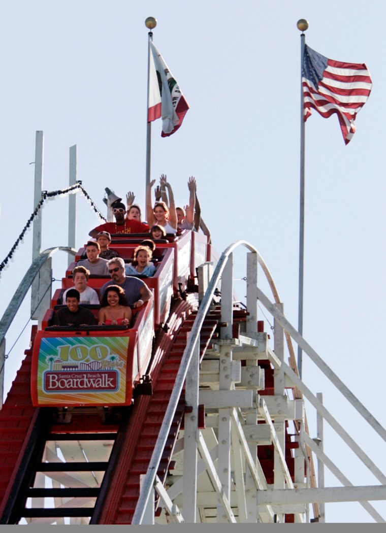 People ride the Big Dipper at the Santa Cruz Beach Boardwalk in Santa Cruz, Calif. The giant roller coaster, a National Historic Landmark, remains the signature ride at the boardwalk. It began thrilling visitors on May 17, 1924, and its 500 feet of twisting track and wooden construction survived the 1989 Loma Prieta earthquake. 