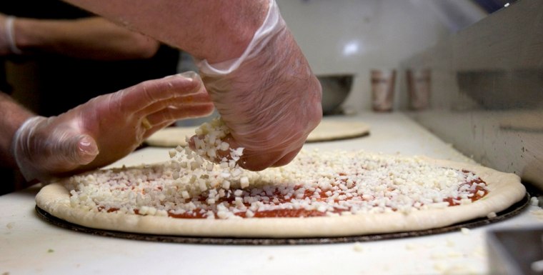 Sharply rising cheese prices has pizza restaurant owners watching the cheese on their pizzas like this one being prepared at Constantly Pizza in Concord, N.H.