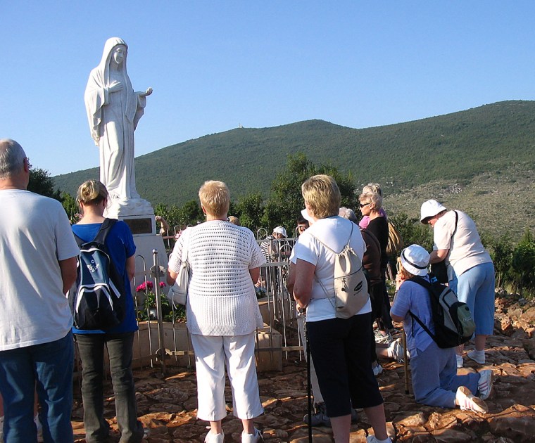 Nora McNulty, 63, seen kneeling at right, is a Scottish grandmother who was among pilgrims from Scotland who made a trip recently to Bosnia's Apparition Hill, where the Virgin Mary is said to have appeared to six children in 1981. 