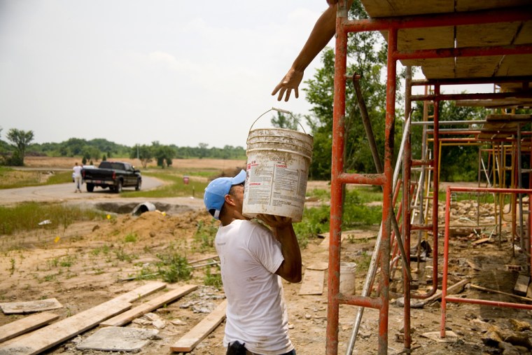 Hispanic workers hoist a bucket at a construction site near Tulsa, Oklahoma, where recent state and local immigration rules are emerging in the absence of federal legislation.