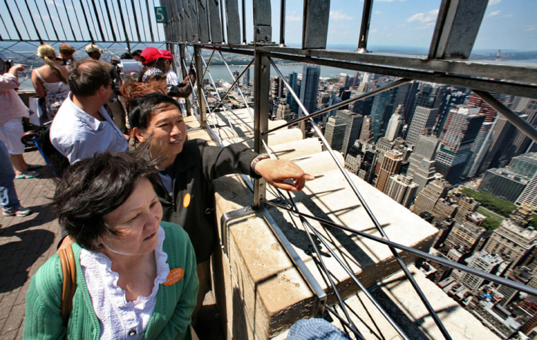 Li Jian Rong, left, and her husband Cao Yin, tourists from Kun Ming, China, get a view of the city from the Empire State building observatory in New York.