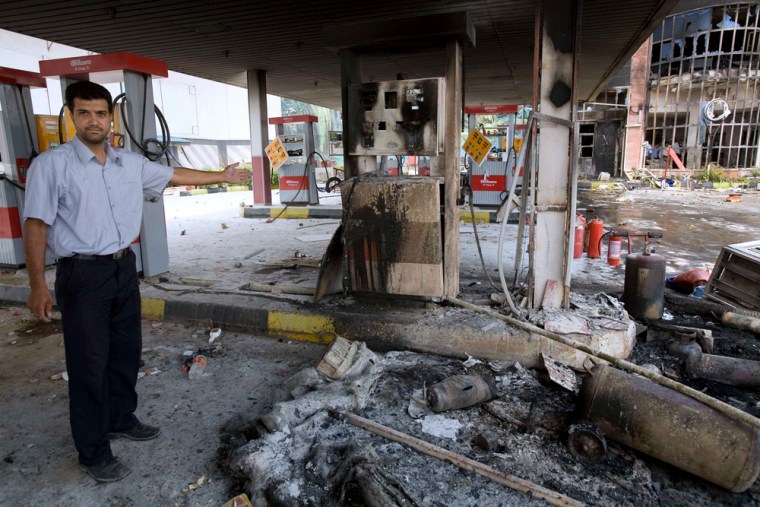 A man shows the damage on a gas station which was destroyed in northwest Tehran