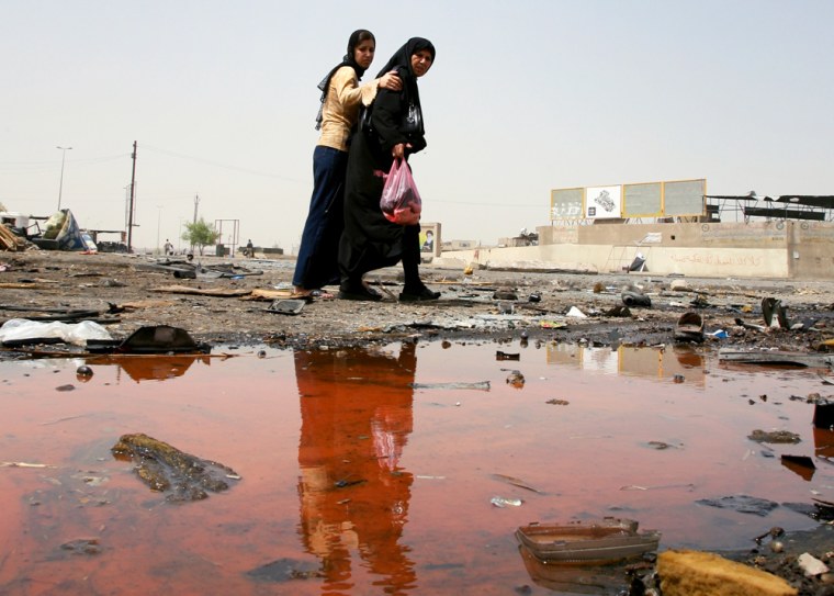 Iraqi women look at the site of a blast at a bus station in the Baiyaa neighborhood in Baghdad, Iraq, on Thursday.
