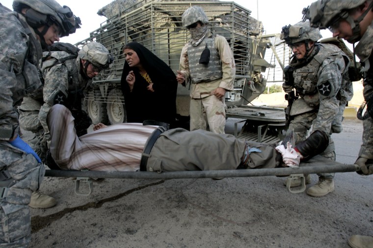 U.S. soldiers of the 2nd brigade, 23rd Infantry Regiment, carry an Iraqi man who was injured during an attack by suspected insurgents during a joint U.S and Iraqi forces operation in southern Baghdad, Iraq, early June 19.