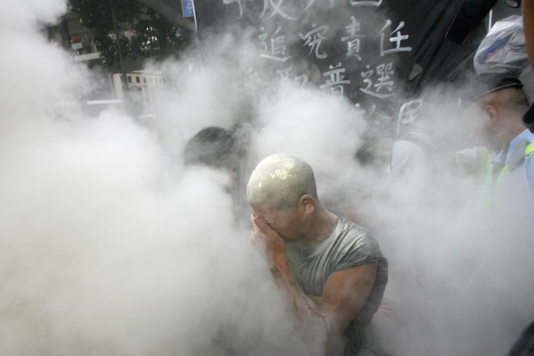 A pro-democracy protester protects himself as police use fire-extinguishing powder in Hong Kong