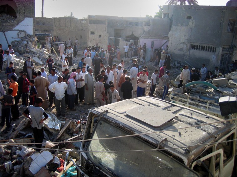 Iraqis gather at the scene of an air strike in Diwaniyah, 130 kilometers (80 miles) south of Baghdad, Iraq, Monday, July 2, 2007. Six houses in Salim Street in al-Jimhouriyah neighborhood in Diwaniyah city were hit by a coalition air strike that left  10 civilians killed, including women and children, and 25 wounded, police in Diwaniyah said. (AP Photo/Jalal Mudhar)