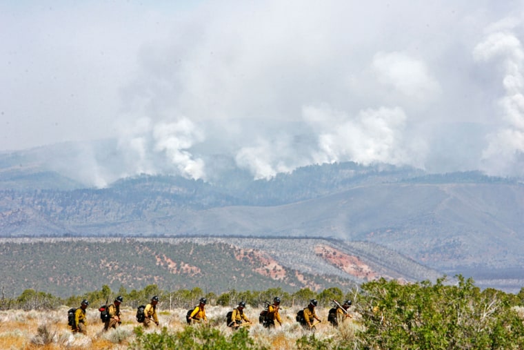 Firefighters hike in to help fight a wildfire north of Roosevelt, Utah on Sunday.