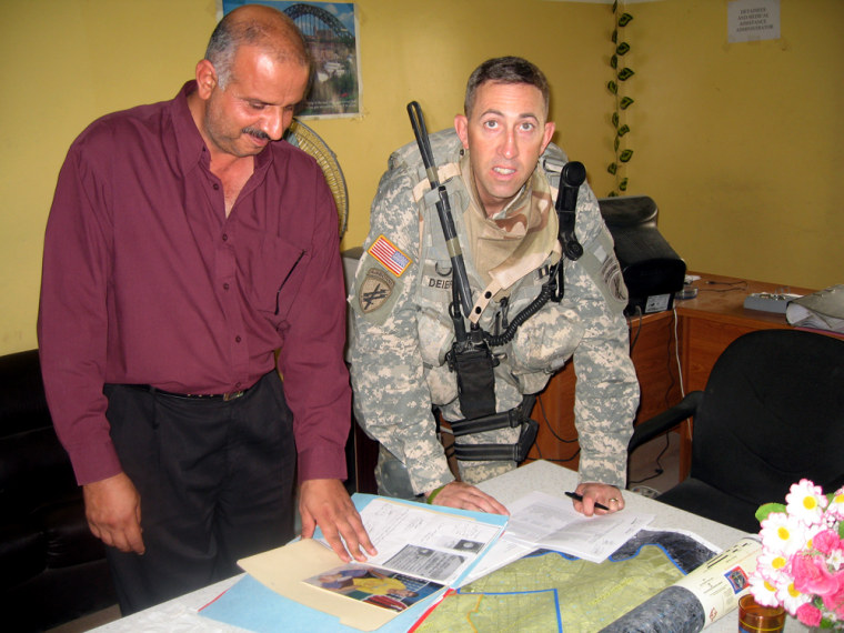 U.S. Army Capt. Tom Deierlein, right, worked with a representative of the Iraqi Assistance Center to determine where to distribute donated charity items.
