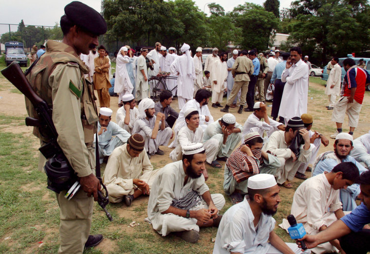 Pakistani religious students and others sit on a ground after their surrender near Lal Masjid, or Red Mosque, on Wednesday in Islamabad, Pakistan. 