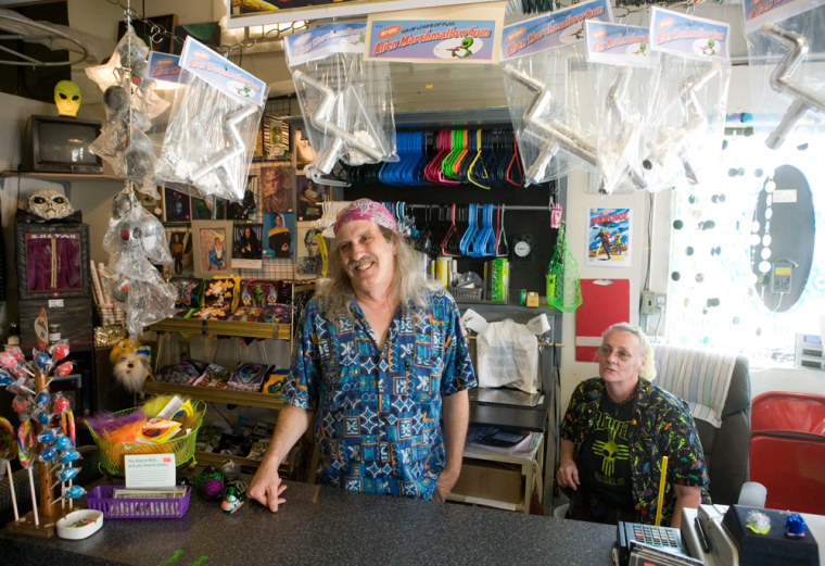 Larry Welz, left, and his wife, Sharon, talk about the UFO phenomenon in Roswell, N.M. in their souvenir shop, The Roswell Space Center. The Welzes said customers often complain there's not enough to satisfy their appetites for UFO fun.