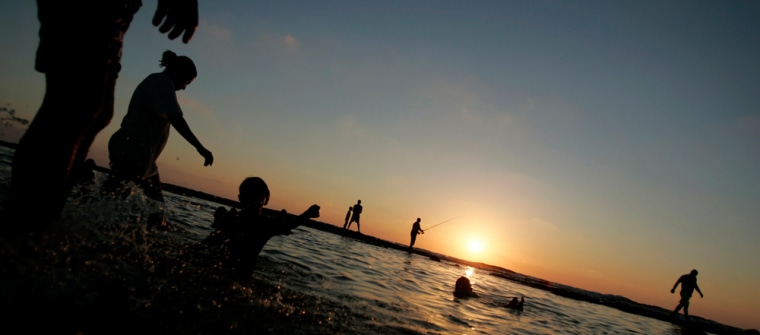 Israelis swim during sunset in the coastal city of Nahariya
