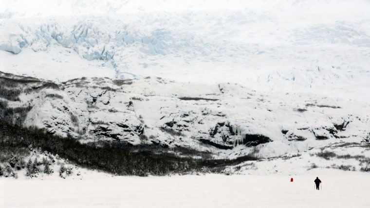A lone, cross-country skier is dwarfed by the Mendenhall Glacier, just 12 miles from the heart of downtown Juneau.