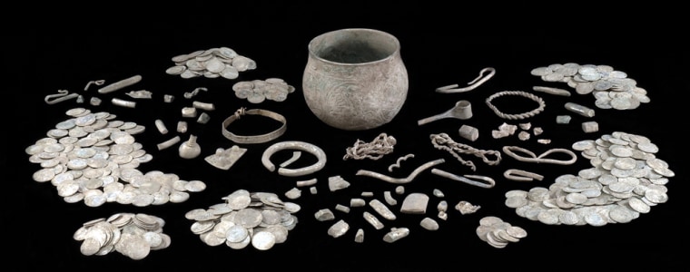 A 9th-century gilt silver vessel, discovered by a father-son team of treasure hunters, sits in the middle of this display of a Viking hoard. More than 600 coins and 65 other items were found in and around the vessel.