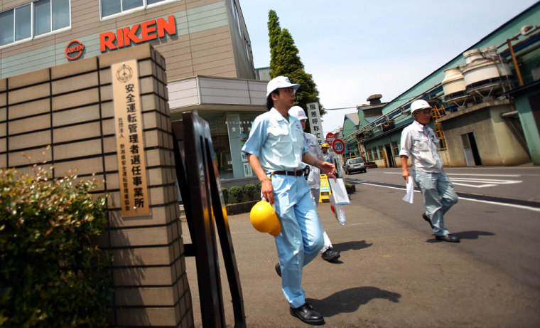 Workers walk out at a gate of Riken Corp.'s Kashiwazaki plant, one of prime auto parts suppliers to Toyota Motor Corp. in Kashiwazaki, Japan, on Thursday. Japanese automakers, including Toyota Motor Corp., will halt production at factories because of quake damage at the major parts supplier.