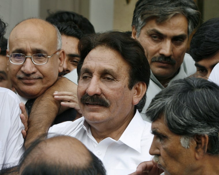 Reinstated Chief Justice Chaudhry walks with his supporters at his residence after the court decision in Islamabad