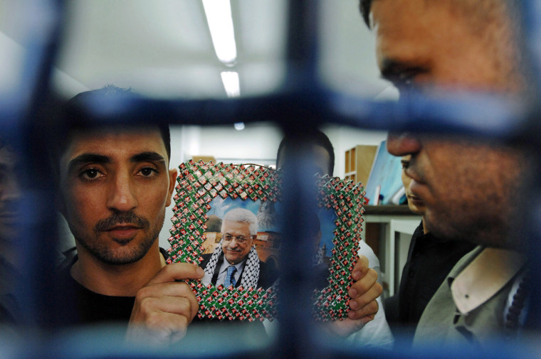 Palestinian prisoner holds a picture of President Abbas before release in southern Israel