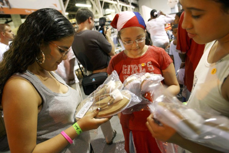 Tanairi Masterreno, 14, left, her sister Maribel Masterreno, 11, center, and Emma Lee Jimenez, 11, take a moment to look at their new summer shoes after receiving them at the Soles4Souls World Vision Summer Shoe Giveaway in the Bronx borough of New York, on July 11, 2007. 