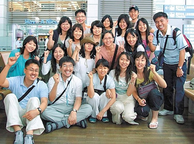 A group of South Koreans pose before leaving for Afghanistan on July 13 at Incheon International Airport west of Seoul, South Korea. They were allegedly kidnapped by the same group that claimed responsibility for a German hostage's death.