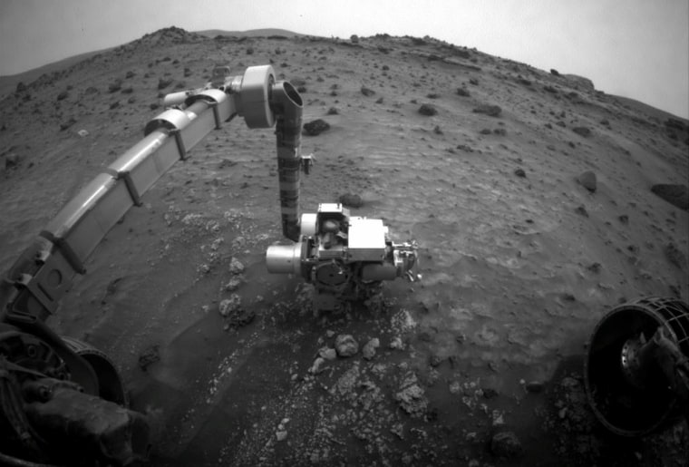 The Spirit rover stretches out its robotic arm to make observations on July 20, in the midst of dust storms sweeping the Red Planet.