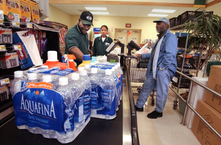 A cashier at a Washington, D.C. store scans a customer's groceries in this file photo. Aquafina water bottles soon will include labeling to spell out that the drink comes from the same source as ordinary tap water.