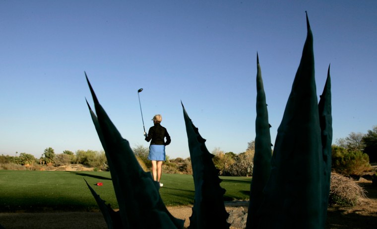 Barbara Hoene watches her tee shot at Desert Willow golf course  in Palm Desert, Calif., April 18, 2007. The course designed with drought tolerant plants to save water. With its lush golf courses and waterfalls, Palm Desert is the epitome of environmental excess. But this desert resort has become an unlikely model for how to deal with global warming, running buses on fuel cells, encouraging residents to commute in electric golf carts and even banning drive-through windows. (AP Photo/Chris Carlson)