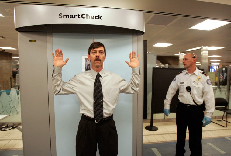 A man passes through an X-ray security scanner as TSA officer Tim Engelby controls the device at Phoenix's Sky Harbor International Airport earlier this year.  It’s time to stop thinking of the checkpoints, the uniforms, the magnetometers and the long lines as the last line of defense terrorist hijackers — and more as part psychological deterrent, part safety blanket for nervous airline passengers, travel columnist Christopher Elliott writes.