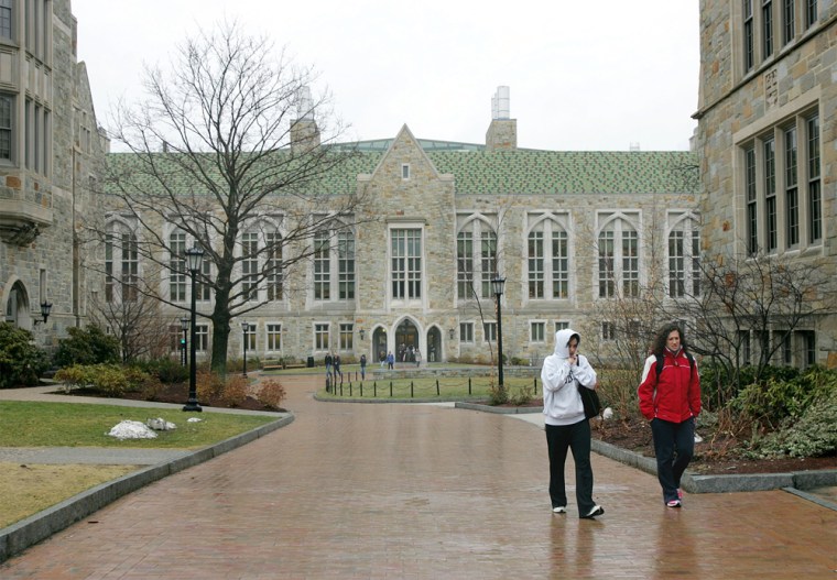 Two Boston College students are seen walking across campus recently. College students are carrying an average of $19,000 in debt by their senior year, according the U.S. Department of Education.
