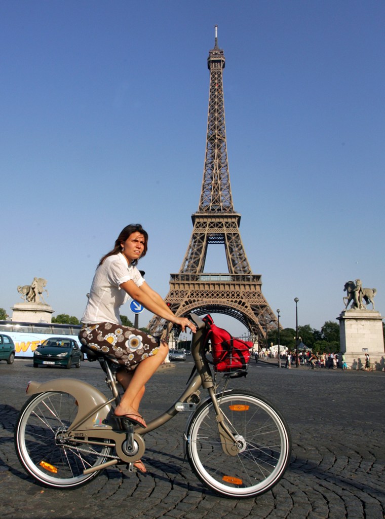 A rider uses a new bicycle provided by Paris City Hall, around the Eiffel Tower in Paris. More than 10,600 bikes are posted at 750 stations all over the city and prices start at a euro (U.S. $1.36) for a one-day pass. Users can take a bike and put it back at any station around town.