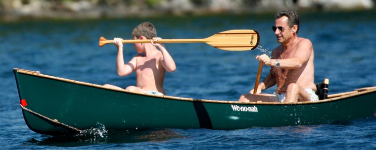 France's President Nicolas Sarkozy paddles a canoe with his son Louis on Lake Winnipesaukee