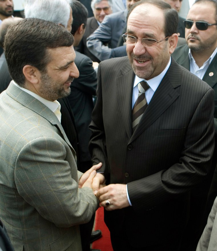 Iraq's Prime Minister Nuri al-Maliki shakes hands with Iran's ambassador to Iraq Hassan Kazemi-Qomi as he arrives at Tehran's International airport