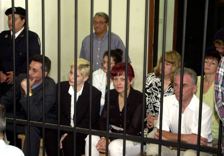 Foreign healthcare workers watch proceedings from inside the defendants' cage in a courtroom in Benghazi, Libya, in May 2004.