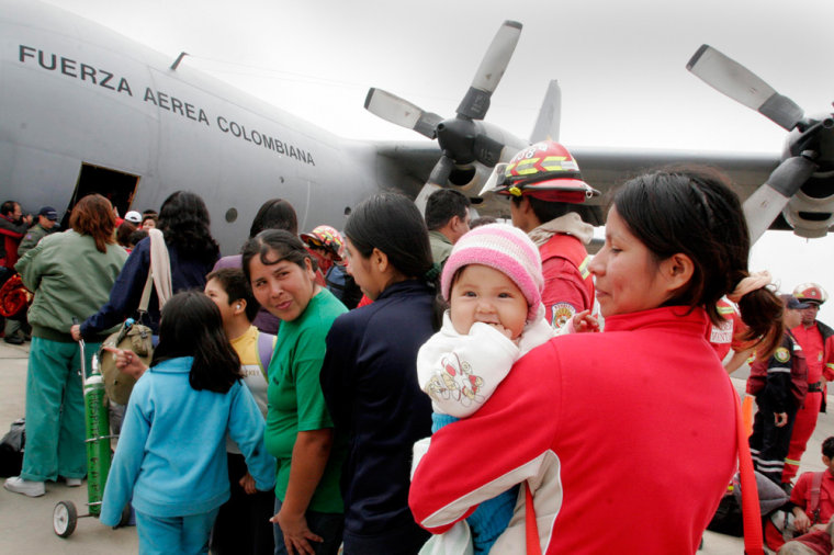 Earthquake survivors wait to be evacuated in an aircraft belonging to the Colombian Air Force at the airport in Pisco
