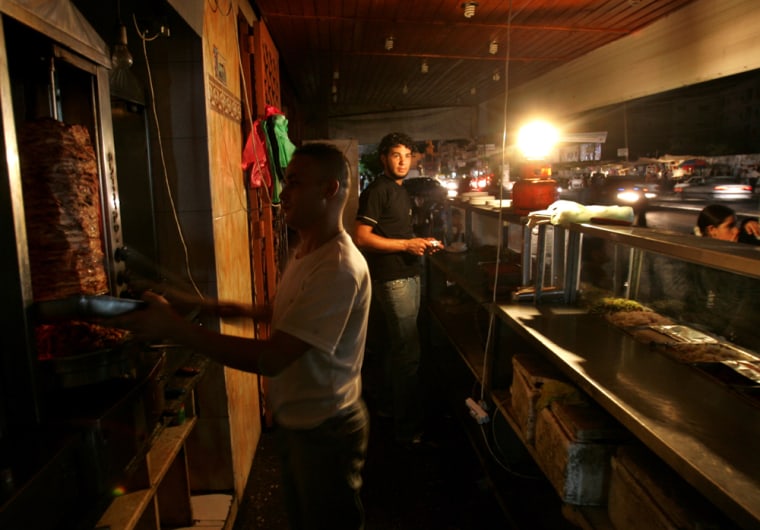 Palestinians use propane to light their restaurant in Gaza City on Sunday  after the electricity was cut.