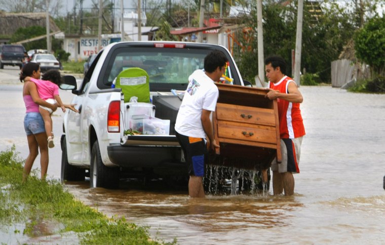 Residents of Bacalar, Mexico, move their furniture away from a flooded area after the passage of Hurricane Dean on Tuesday.