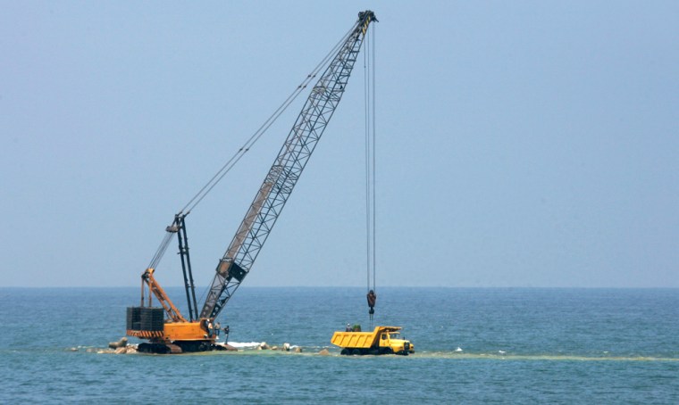 Rocks are unloaded by crane from a truck on a partially-completed coastal defense breakwater in Alexandria, Egypt, May 15, 2007. The Mediterranean Sea is creeping higher, flooding parts of the Egyptian shoreline in an inexorable process caused by global warming but in Egypt, as in much of Africa, global warming is rarely discussed and the debate over climate change is submerged by immediate problems such as poverty, disease and overpopulation. (AP Photo/Ben Curtis)
