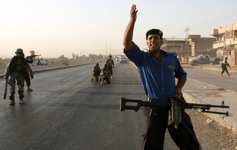 Members of the Iraqi security forces put up a road block Monday after unidentified gunmen opened fire on pilgrims on their way to the city of Karbala.