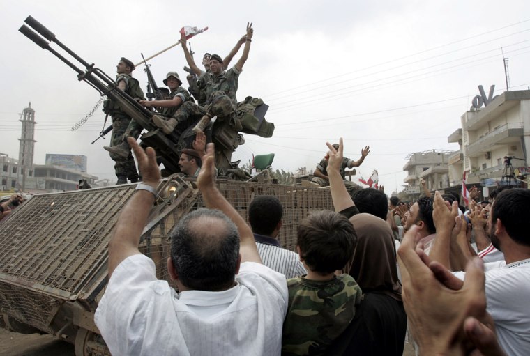 Lebanese soldiers leaving the Nahr el-Bared Palestinian refugee camp, stand on their armored personnel carrier surrounded by cheering residents as they celebrate the end of fighting in the northern city of Tripoli, Lebanon, on Monday. 