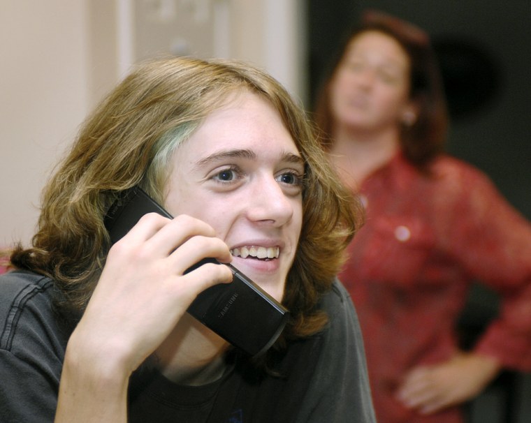 Sam Hill, 13, an eighth grader, speaks on a cell phone as his mother Carlton Hill, looks on in their Atlanta home. The Hill's have been using parental controls for the past four months on their cell phones. AT&T Inc., the United States' largest wireless carrier, will launch a service Tuesday giving parents wide-ranging control on almost all of its 63.7 million subscriber lines. 