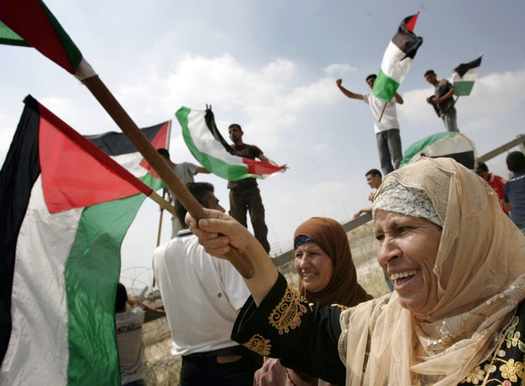 Palestinians celebrate Tuesday the Israeli Supreme Court's ruling that the Israeli government must re-route the West Bank barrier.