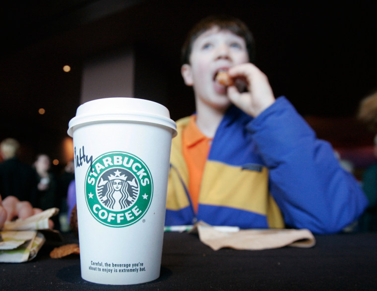 Dustin Doty, 13, enjoys a pastry with his beverage at the Starbucks annual shareholders meeting this year. Doty's mother recently purchased shares of Starbucks stock for him.