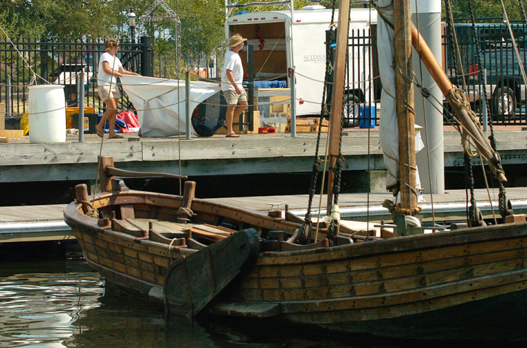 Rebecca Pskowski, left, of Rockville, Md.,, along with William Ryall of Oxford, N.C., right, crew members of the replica of John Smith's shallop, foreground, take down the display tent outside Nauticus in Norfolk, Va., Tuesday, Sept 4, 2007. The replica boat is scheduled to return Sept. 8 to Historic Jamestowne after 121 days recreating Smith's exploration of Chesapeake Bay. (AP Photo/Gary C. Knapp)
