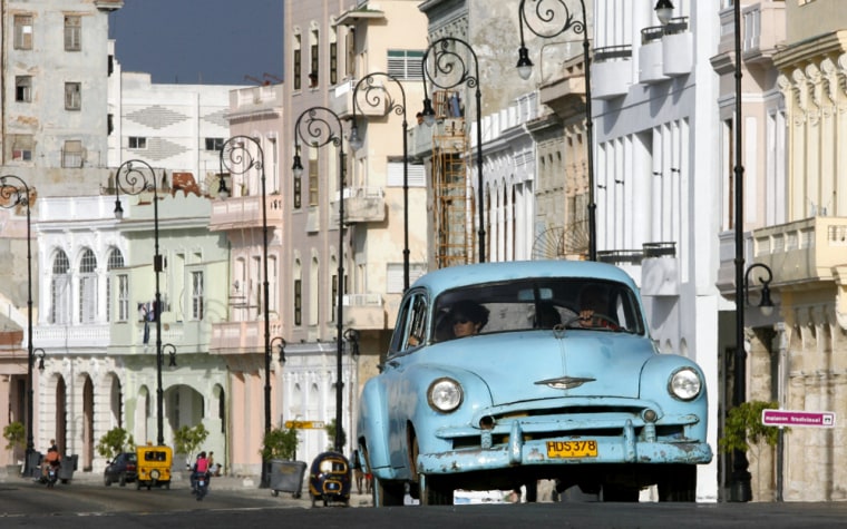 Cubans ride in an old car on Havana's coastal "Malecon". Traveling to Cuba is not illegal for Americans, but the Trading with the Enemy Act prohibits spending money on the island. If caught, unauthorized U.S. tourists can face civil fines of up to $55,000. Even Michael Moore is now being investigated for filming "Sicko" without permission in Cuba.