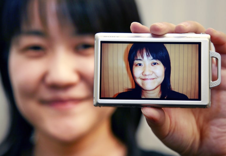 Sony employee displays the new digital camera with smile recognition at the company's Tokyo headquarters, September 5, 2007.