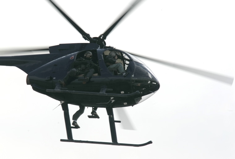 A helicopter owned by Blackwater USA, a private security contractor, flies over central Baghdad. Contractors in Iraq work to provide security, gather intelligence, forge a financial system and transport needed supplies in a country the size of California.