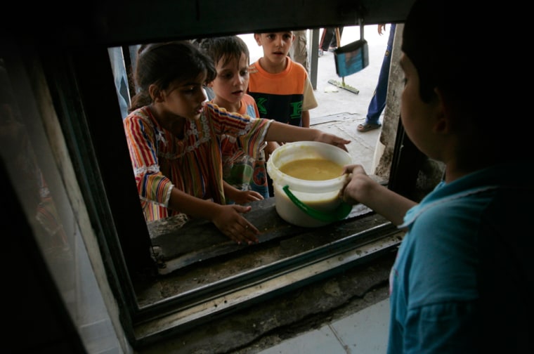 Poor residents receive food during the fasting month of Ramadan at the Sunni mosque of Abdul Qadir al-Gailani in Baghdad