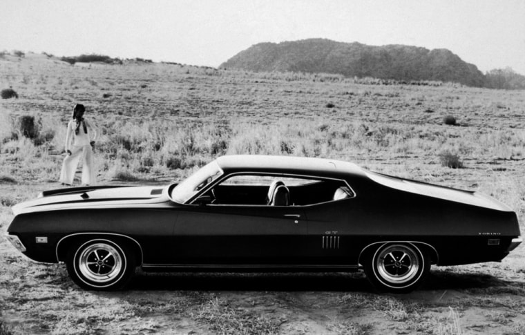 Model w/ Ford GT Torino in desert, 1960s.