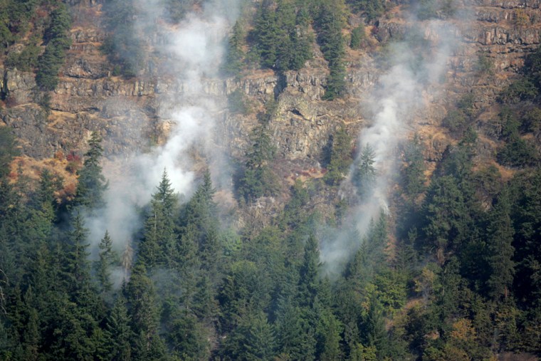 A wildfire burns along the cliffs overlooking the Columbia River near White Salmon, Wash., on Friday.