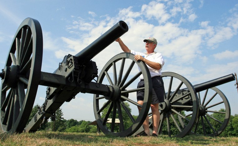 Thomas G. Clemens, a private guide for hire at Antietam National Battlefield in Sharpsburg, Maryland, stands along a row of artillary cannons. Clemens is part of a guide program, run by a local non-profit, that is offering customized tours of the famous Civil War battlefield sites.